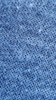 Ayrıntılı dikişleri, dokuyu ve deseni gösteren mavi örgü kumaşın yakın görüntüsü, tekstil ve tasarım kavramları için mükemmeldir.