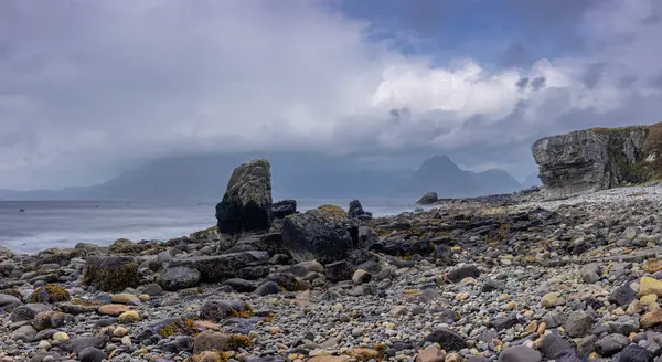 İskoçya, Skye Adası Elgol 'daki Rocky kıyı şeridi, Black Cuillin dağlarını gösteriyor.