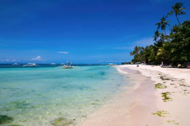 Bohol, Filipinler - 21 Nisan 2018: Filipinler 'in Panglao Adası' ndaki Alona Sahili 'ndeki geleneksel teknelerde turistler ve tekne mürettebatı.