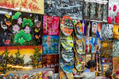 Markette gösterilen renkli tablolar ve dekoratif tabaklar