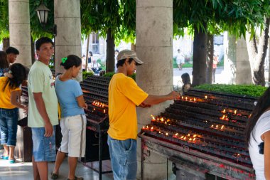 Filipinler 'deki Katolik Tapınağı' nda Erkek ve Kadın Dua Mumları yakıyor