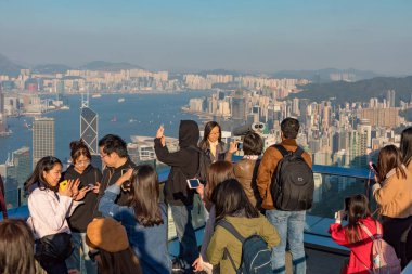 İzleme Platformu 'ndaki kalabalık Hong Kong City Skyline ve Harbour' a bakıyor.