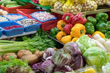 Markette renkli taze sebzeler ve fasulyeler sergileniyor.