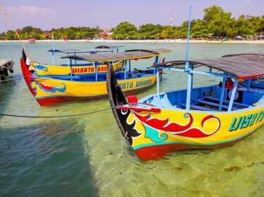 Jepara 'da berrak sularda yüzen renkli tekneler.