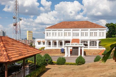 Melaka 'da yeşil manzaralı ve bulutlu tarihi bir bina.