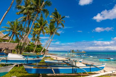 Filipinler 'de tropikal kumsalda dinlenen renkli kayıklar.