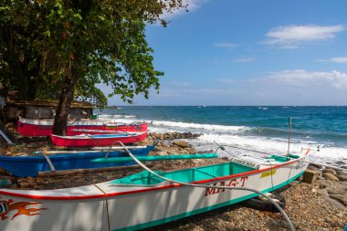 Filipinler 'in güneyinde kayalık kıyı şeridinde dinlenen renkli balıkçı tekneleri