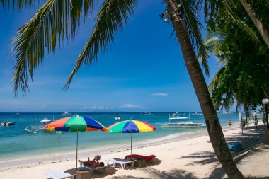 Panglao Adası, Bohol, Filipinler - 20 Nisan 2018: Alona Sahili 'nde güneş ve denizin tadını çıkaran tatilciler.