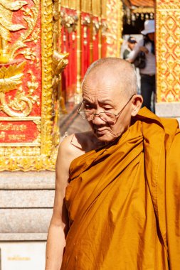 Keşiş süslü tapınak girişinin yanında yürüyor, Tayland Chiang Mai