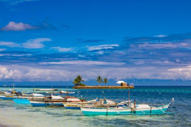 Filipinler 'de tropik ada kıyısında yüzen renkli tekneler