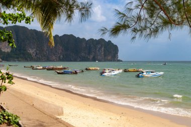 Tayland yengeci. Hint Okyanusu 'nda kayalık kayalıkları olan geleneksel ahşap kuyruklu tekneler.  