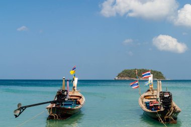 Tayland, Phuket. Andaman Denizi 'nin durgun, turkuaz sularında yüzen iki geleneksel Tayland uzun kuyruklu teknesi..