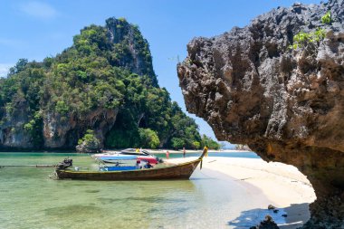 Tayland, Krabi 'de tropikal bir plaja demirlemiş uzun kuyruklu tekneler. ziyaretçi çekim yeri 