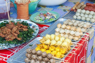 Markette çeşitli ızgara et şişleri sergileniyor.