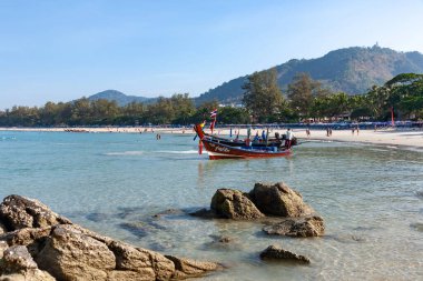 Phuket. Tayland. Kumlu sahile demirlemiş pek çok sürat teknesi ve uzun kuyruklu tekneleri olan tropik sahil manzarası..