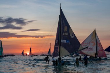 Boracay, Filipinler - 08 Nisan 2018: Günbatımında White Beach 'te yelkenli tekneler ve tur tekneleri         