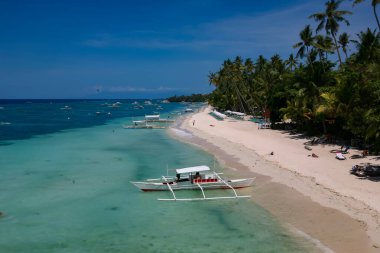 Bohol, Filipinler - 21 Nisan 2018: Filipinler 'in Panglao Adası' ndaki Alona Sahili 'ndeki geleneksel teknelerde turistler ve tekne mürettebatı.