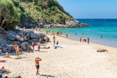 Turkuaz su, beyaz kum ve güneşten hoşlanan insanlarla dolu Idyllic Thai plajı. Tayland Phuket