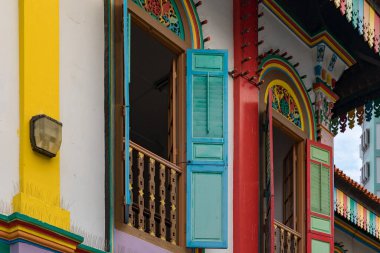 Açık ahşap pencereler ve süslü detaylar içeren renkli boyanmış bina, Küçük Hindistan, Singapur