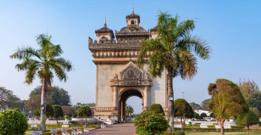 Palmiye ağaçları ve Patuxai Zafer Kapısı mavi gökyüzüne karşı, Vientiane 'deki savaş anıtı, Laos. 
