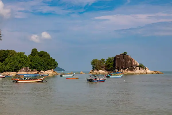 Kayalık tropik adaların yakınında yüzen renkli tekneler, Malezya Pengonu