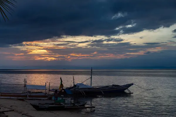 Sakin okyanus sularına yansıyan renkli günbatımı, Filipinler Camotes