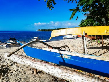 Camotes 'daki kumlu sahilde dinlenen renkli tekneler.