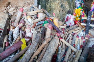 Ahşap fallik heykel ya da lingam yığını, çoğu kırmızı uçlu boyalı, bir türbe ya da mağara girişinde sunulan