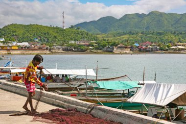 Filipinler 'in Palawan Eyaleti' ndeki Busuanga Adası 'nda bulunan Coron Körfezi' nde demirleyen Asyalı adam..