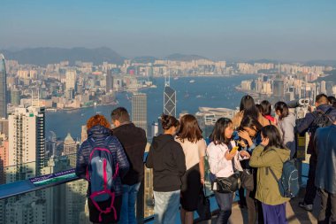 İzleme Platformu 'ndaki kalabalık Hong Kong City Skyline ve Harbour' a bakıyor.