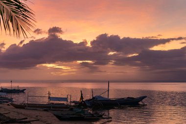 Sakin tropikal sulara yansıyan renkli günbatımı, Filipinler Camotes