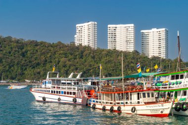 Tekneler Pattaya sahiline yanaştı, arkasında binalar var.