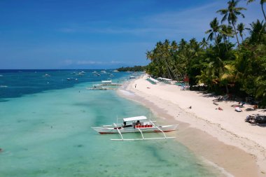 Bohol, Filipinler - 21 Nisan 2018: Filipinler 'in Panglao Adası' ndaki Alona Sahili 'ndeki geleneksel teknelerde turistler ve tekne mürettebatı.