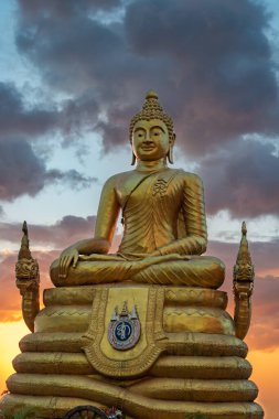 Phuket, Tayland 'daki dev altın Buda heykeli dramatik bir günbatımı gökyüzüne karşı