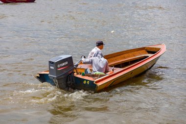 Brunei 'de motorlu tekne süren adam.
