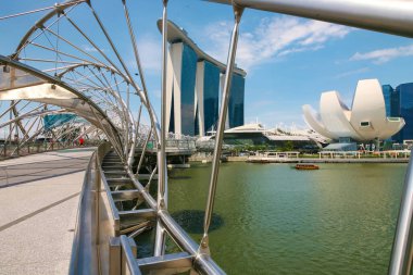 Arka planda Marina Bay Sands oteli ile Helix Köprüsü 'nde yürüyen turistler ve yerliler. Singapur