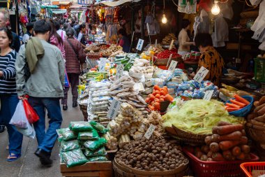 Kalabalık tezgahlarla dolu kalabalık bir sokak manzarası ve oradan geçen müşteriler..
