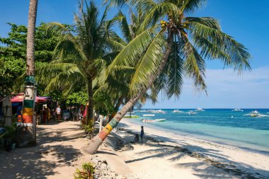 Panglao Adası, Bohol, Filipinler - 20 Nisan 2018: Alona Sahili 'nde güneş ve denizin tadını çıkaran tatilciler.
