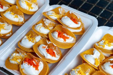 Beyaz tepsilerde dinlenen renkli Tayland tatlıları