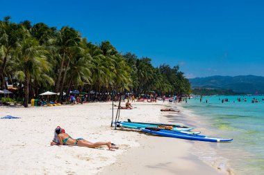 Boracay, Filipinler 'deki White Beach' te dinlenen turistler.       