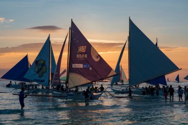 Boracay, Filipinler - 08 Nisan 2018: Günbatımında White Beach 'te yelkenli tekneler ve tur tekneleri         