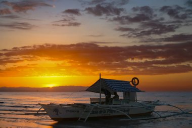Gün batımında yüzen balıkçı teknesi, Filipinler Bohol