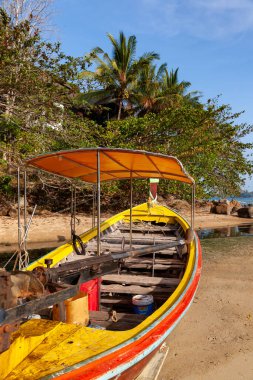 Phuket 'teki kumlu sahilde dinlenen renkli bir tekne.