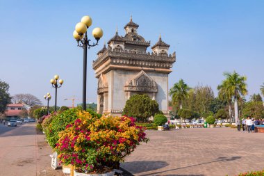 Parlak çiçekler, yeşil ağaçlar ve Patuxai Zafer Kapısı, Vientiane Laos 'un kalbinde bulunan önemli bir savaş anıtı.. 