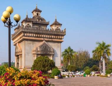 Parlak çiçekler, yeşil ağaçlar ve Patuxai Zafer Kapısı, Vientiane Laos 'un kalbinde bulunan önemli bir savaş anıtı.. 