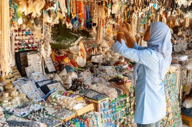 Kadın renkli mücevher pazarında el yapımı aksesuarlar sergiliyor, Tayland, Yengeç...
