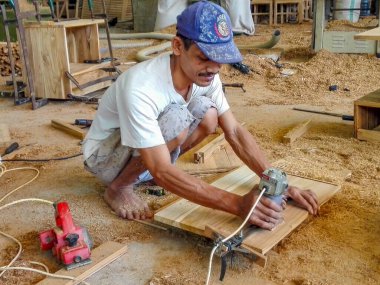 Jepara, Endonezya 'daki atölyede odunla çalışan Asyalı marangoz.