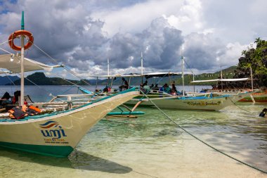 Palawan, Filipinler 'de gündüz vakti sığ sularda demirli Yolcularla Tur Tekneleri