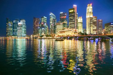 Singapur silueti gece vakti suya yansıyor