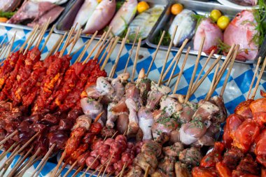 Detail view of food stall with fresh seafood and meat skewers at night market, Philippines